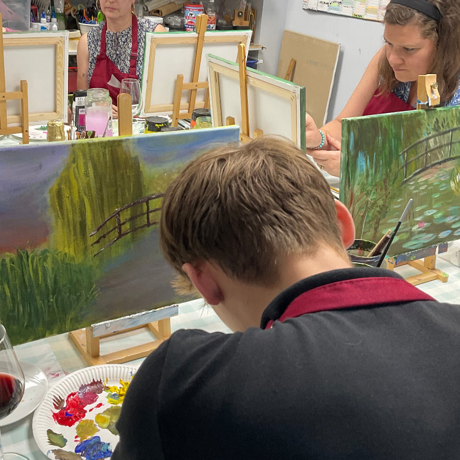 Art class scene with students painting landscapes in a studio setting.