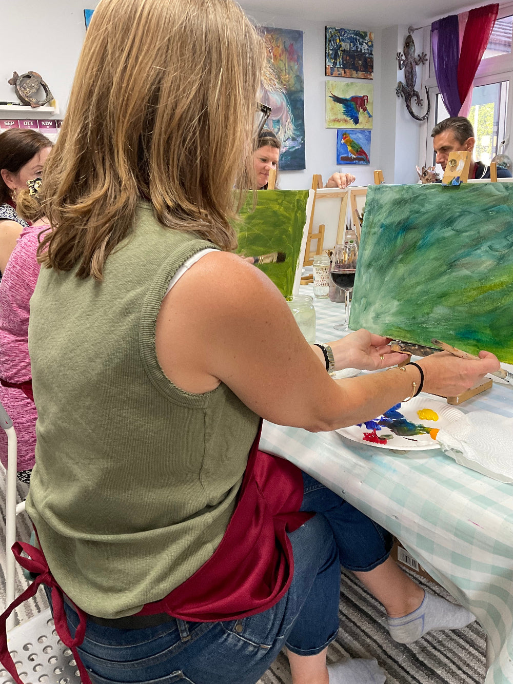 Person painting with a collage of art pieces in the background