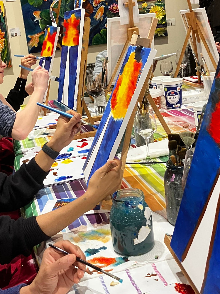 Art studio with artists painting and artwork on easels